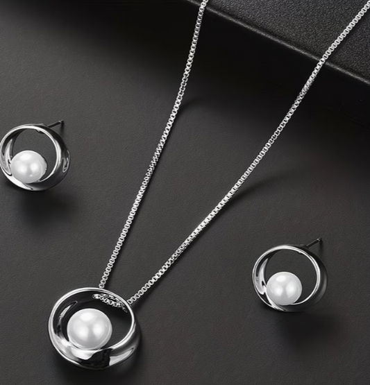 Silver tone pearl necklace and matching earrings set with circular geometric design