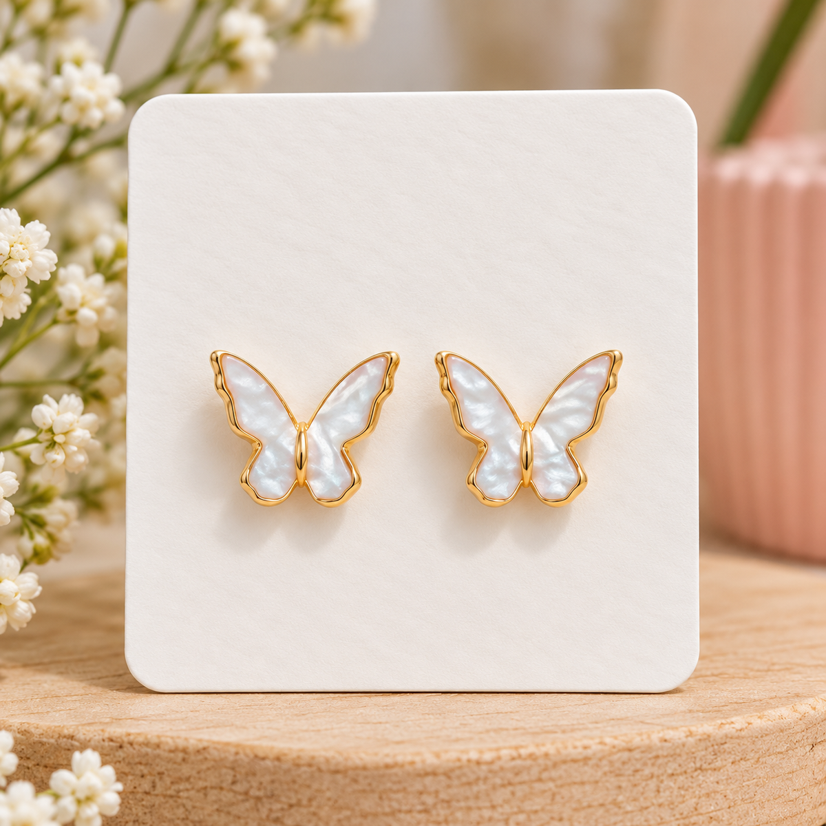 Pearl white butterfly stud earrings with iridescent wings and gold-tone trim