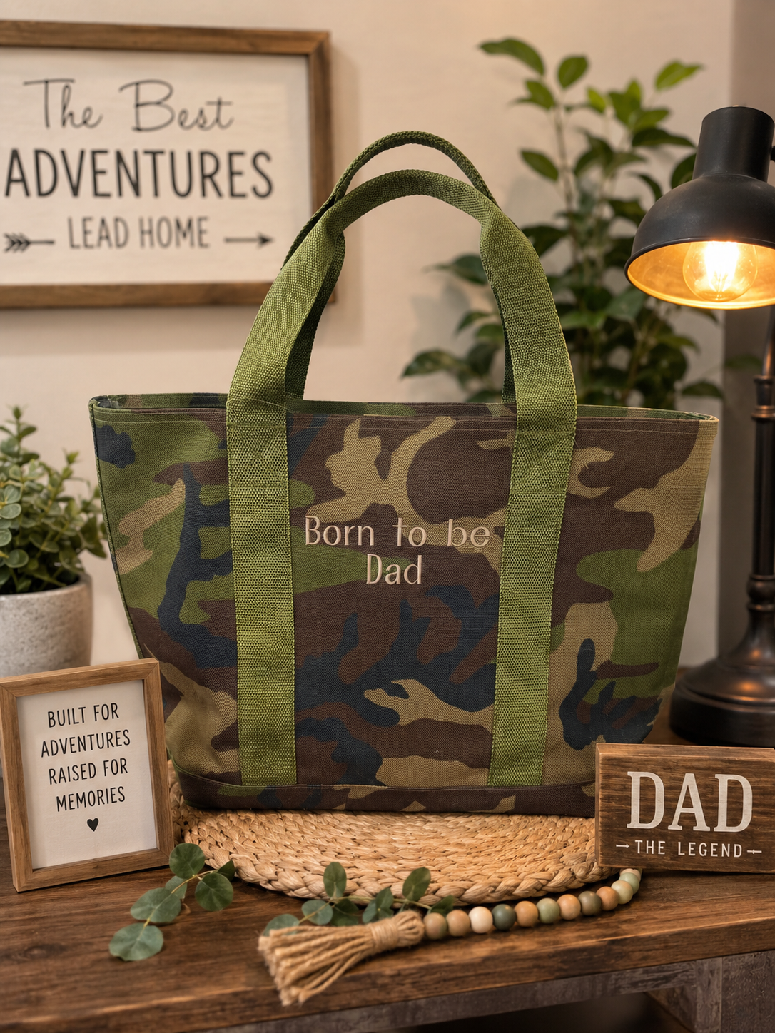Personalized camouflage LL Bean tote bag embroidered with "Born to Be Dad" displayed in a rustic home setting.