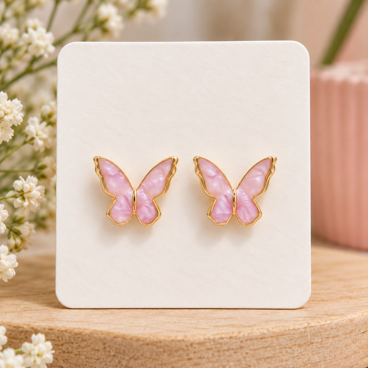 Pink butterfly stud earrings with pearly marbled wings and gold-tone trim