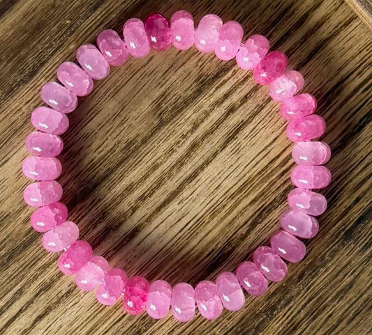 Pink beaded bracelet on a wooden surface
