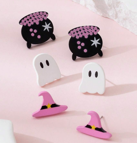 Set of Halloween-themed earrings including ghosts, witch hats, and cauldrons on a pink background.