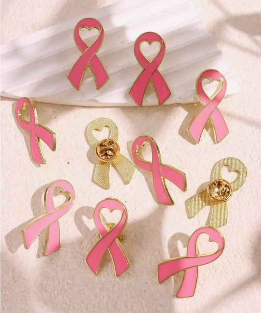 Pink ribbon earrings with gold accents on a white fabric background