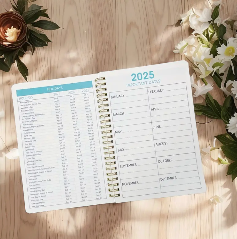 Floral print 2025–2027 monthly planner with double wire binding and elastic closure shown open to a monthly spread.