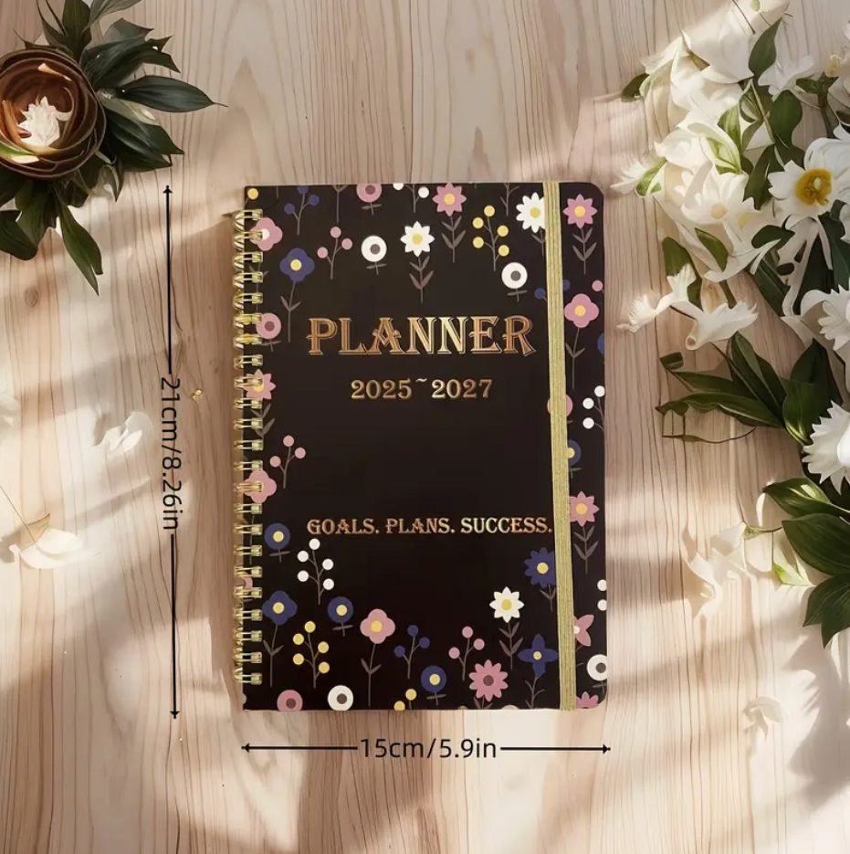 Floral print 2025–2027 monthly planner with double wire binding and elastic closure shown open to a monthly spread.