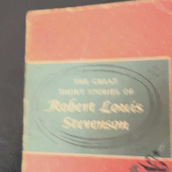 Vintage 1959 Pocket Library edition of The Great Short Stories of Robert Louis Stevenson displayed on a wooden book stand