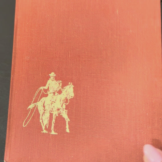 Vintage hardcover copy of The American Cowboy published by National Geographic Society with western-themed cover artwork.