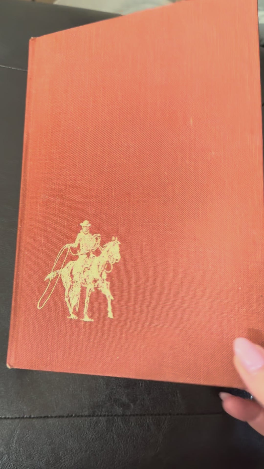 Vintage hardcover copy of The American Cowboy published by National Geographic Society with western-themed cover artwork.