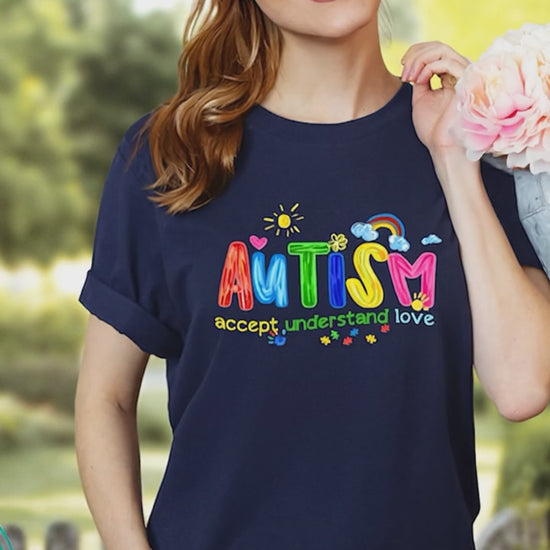 woman wearing navy autism awareness shirt with colorful AUTISM graphic outdoors