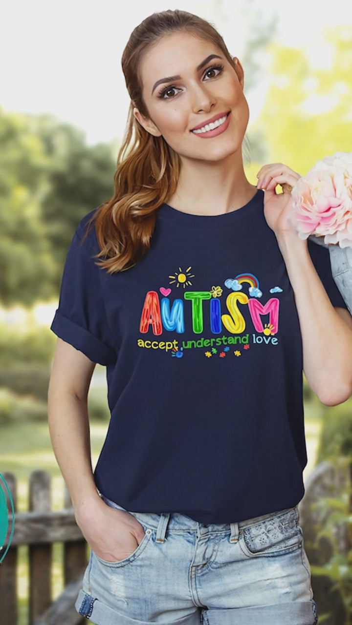 woman wearing navy autism awareness shirt with colorful AUTISM graphic outdoors