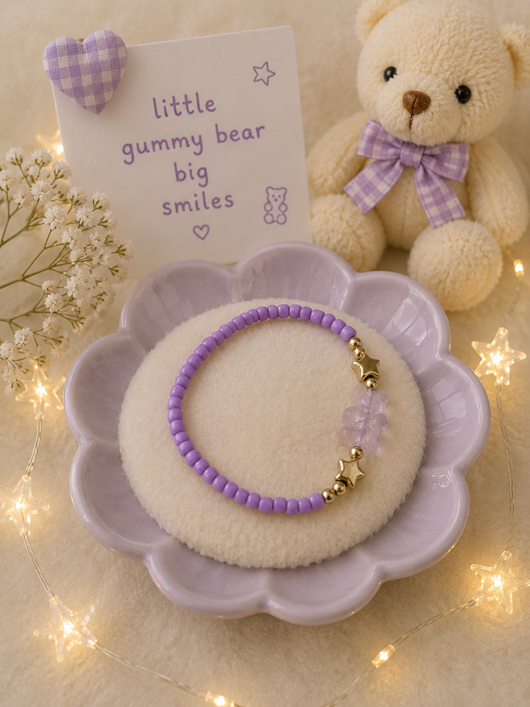 Purple stretch bead bracelet with transparent gummy bear charm and gold star accents in lavender display