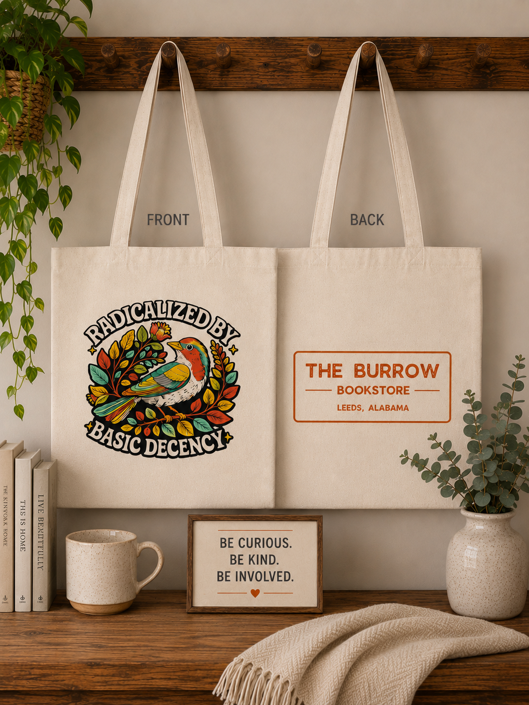 Natural canvas two-sided tote bag featuring a colorful bird with the phrase Radicalized by Basic Decency on the front and The Burrow Bookstore logo on the back.