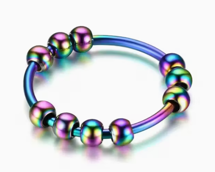 Rainbow beaded spinner fidget ring with iridescent stainless steel band and movable round beads on a white background