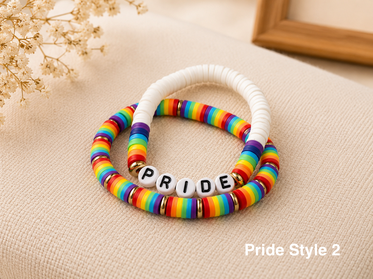 Colorful rainbow pride jewelry bracelets arranged on soft neutral display background