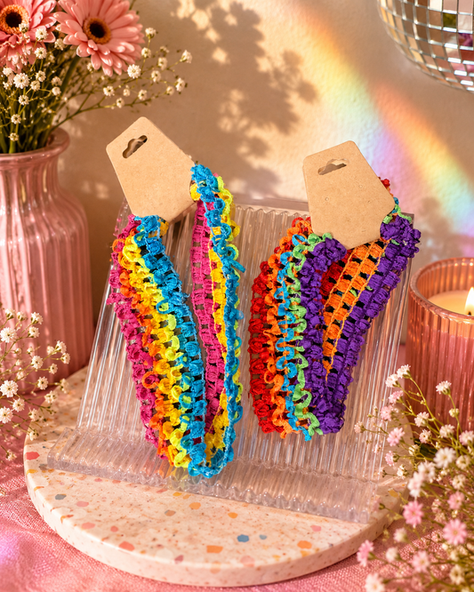 Set of colorful stretchy rainbow headbands featuring bright pink, yellow, blue, orange, and green woven elastic bands.