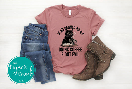 Pink t-shirt with a cat graphic and text, paired with jeans and boots on a white background.