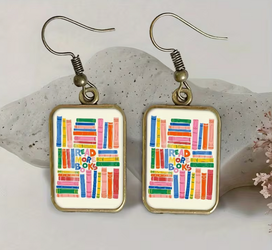 Pair of colorful Read More Books rectangular dangle earrings with antique bronze-tone frames, bookshelf illustrations, and fishhook ear wires.