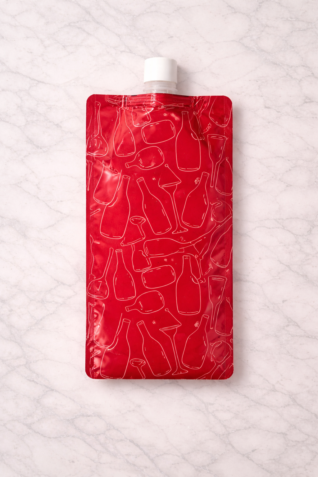 Back view of a red inflatable reusable wine bag with white line art bottle and glass pattern and a white screw cap on a marble background