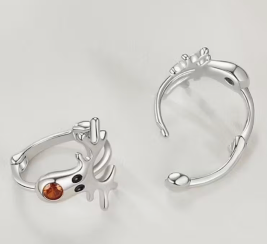 Silver-tone reindeer hoop earrings with antlers and an orange nose shown against a light background.