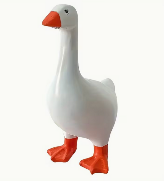 white resin goose figurine with orange beak and feet standing upright on plain background