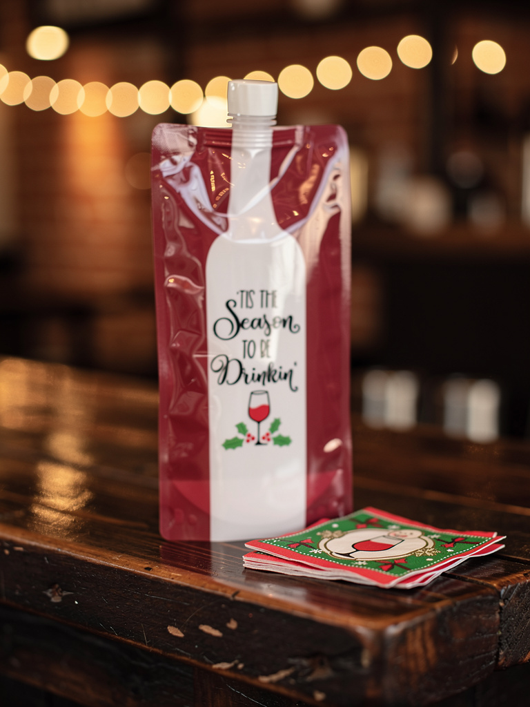 Bottle-shaped packaging with a festive design on a wooden surface.