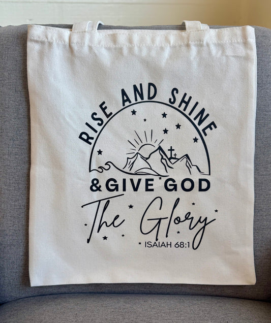 Canvas tote bag featuring the phrase "Rise and Shine & Give God the Glory" in elegant script, perfect for Christian and inspirational gifts.