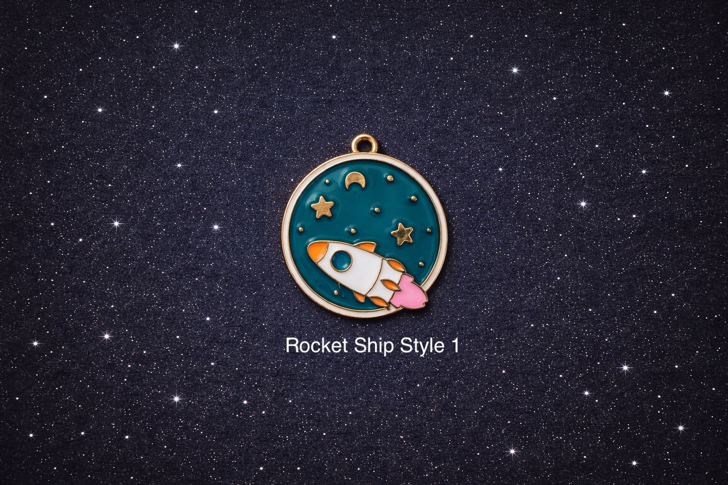 Round enamel space charm with a white and orange rocket ship flying across a teal starry sky with gold stars and moon, shown on a dark starry background and sold individually.