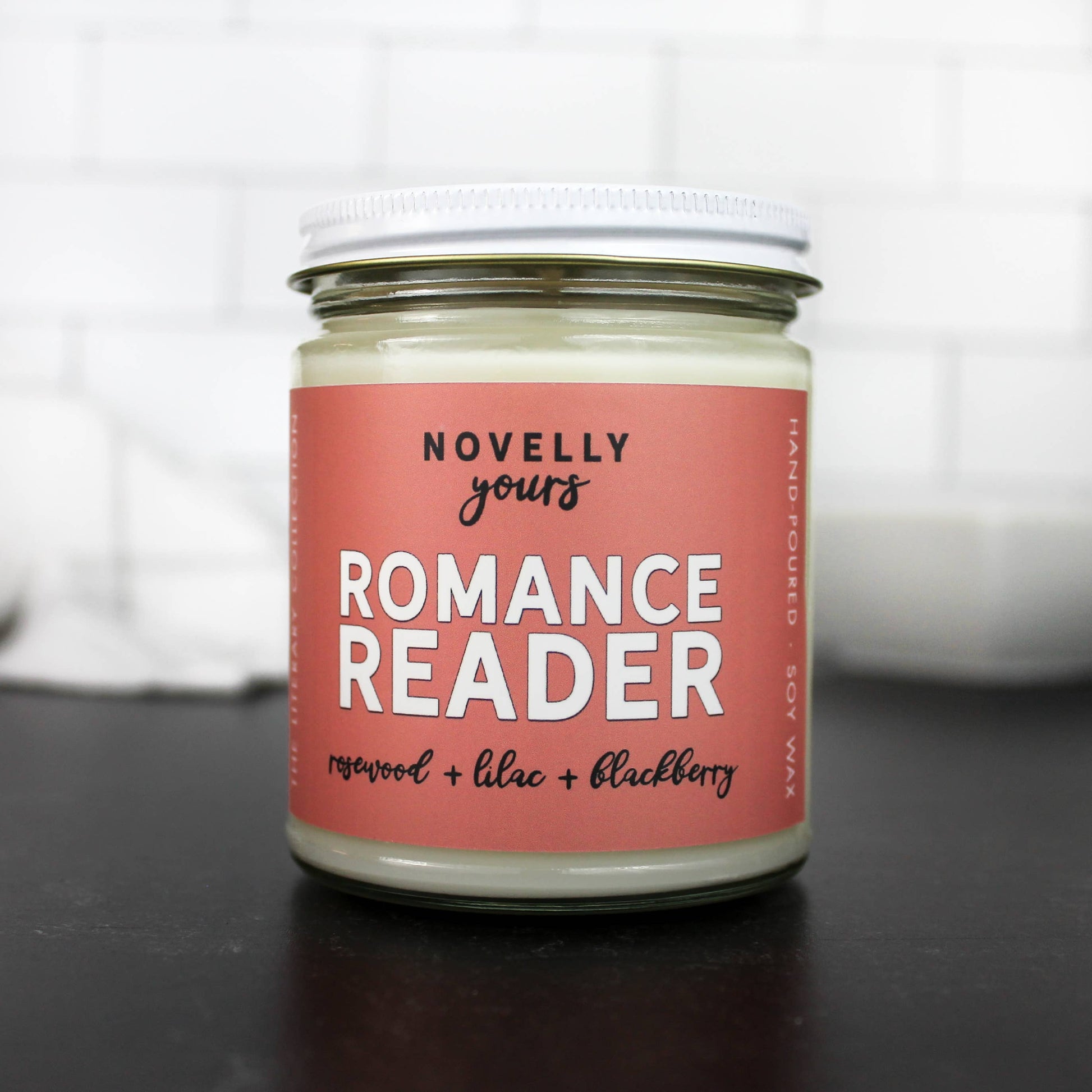 9 oz hand-poured soy candle titled Romance Reader, featuring a romantic fragrance ideal for book lovers and cozy settings.