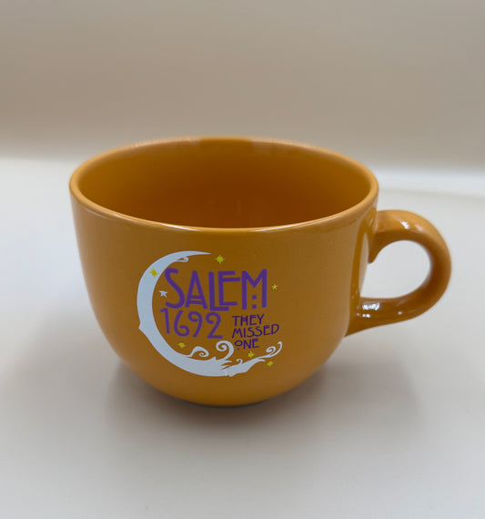 Brown mug with 'Salem 1692 They Missed One' text on a white background