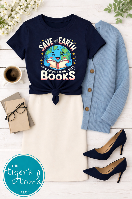 Navy t-shirt with 'Save the Earth, It's the Only Planet with Books' design, paired with a blue cardigan, white pants, black shoes, and a coffee cup on a wooden surface.