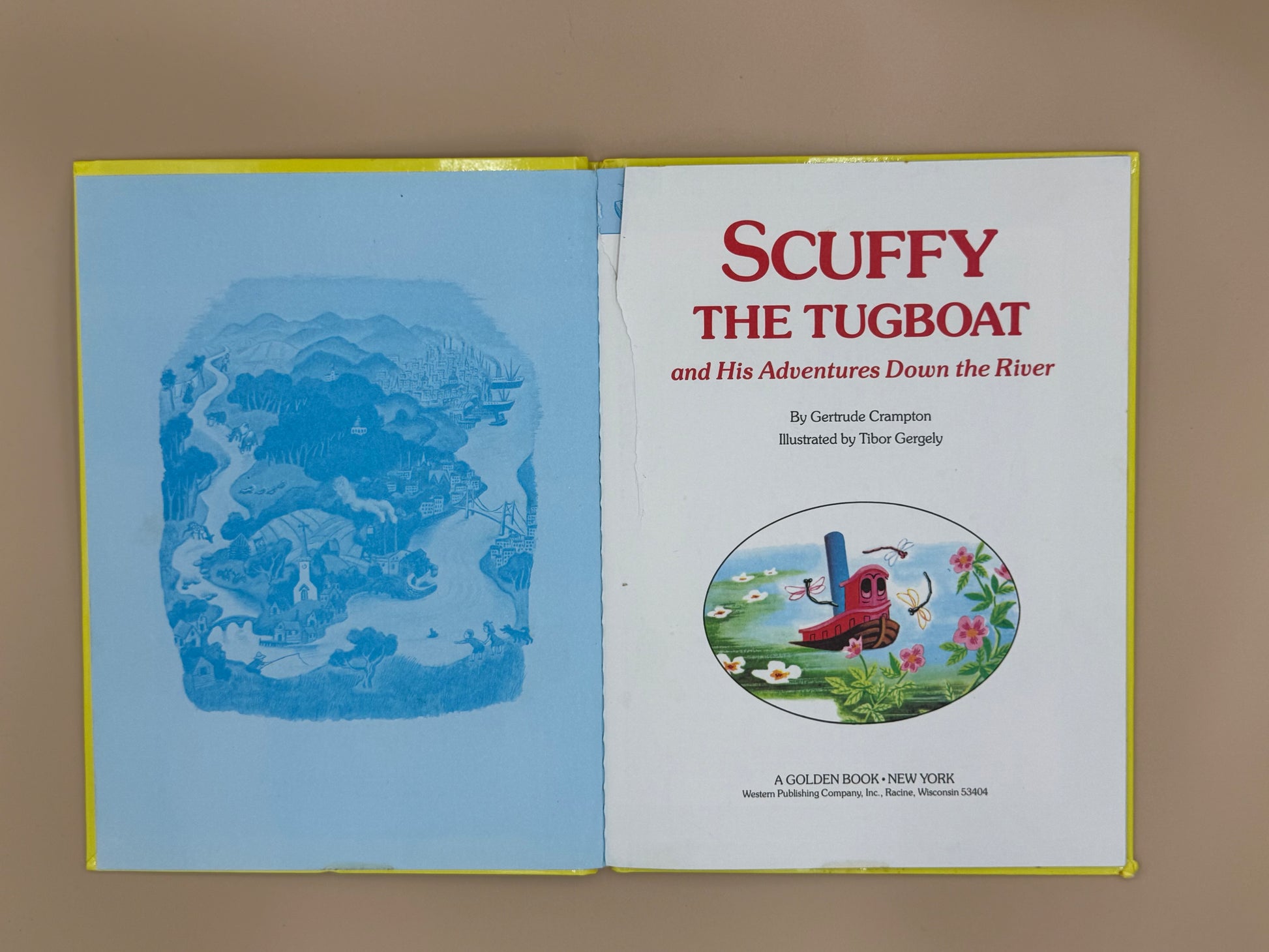Book cover of 'Scuffy the Tugboat and His Adventures Down the River' by Gertrude Crampton on a beige background.