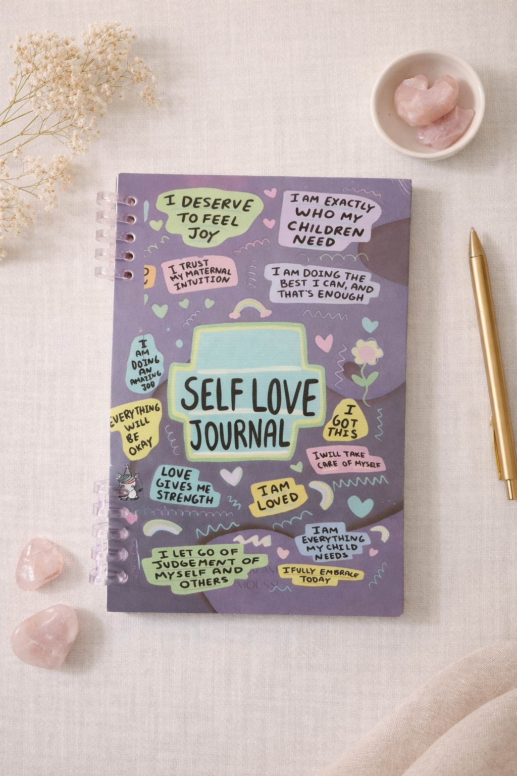 Self love journal for moms with colorful affirmation cover, spiral bound self care journal styled on neutral linen background with crystals and gold pen