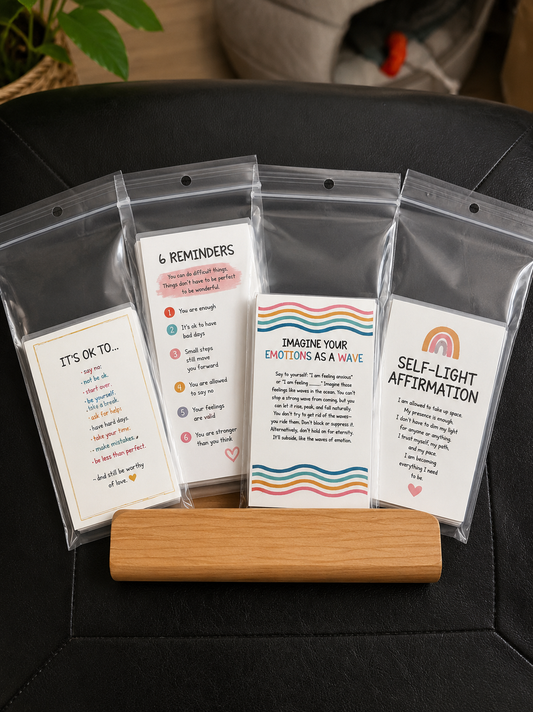 Set of 14 mindfulness and self-mantra affirmation cards displayed in clear pouches with a wooden stand on a black chair for mental health and self-care use