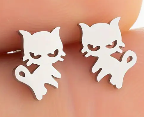 Silver cat-shaped earrings on a blurred background