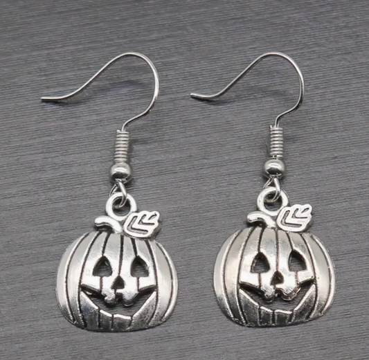 Silver pumpkin-shaped earrings on a gray background