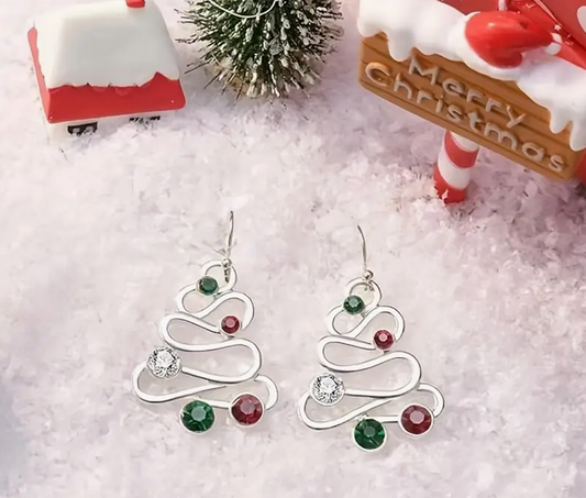 Silver Christmas tree earrings with colored stones on a snowy background