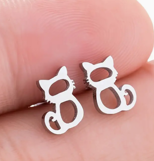 Cat-shaped silver earrings on a hand
