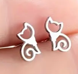Silver cat-shaped earrings on a light skin background