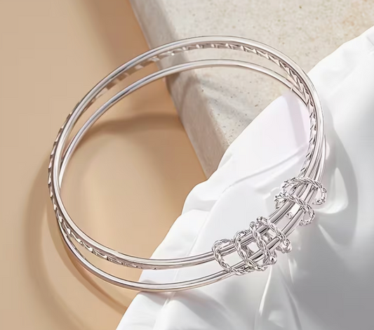 Silver-tone adjustable cuff bracelet featuring a wrapped wire accent and textured band design.