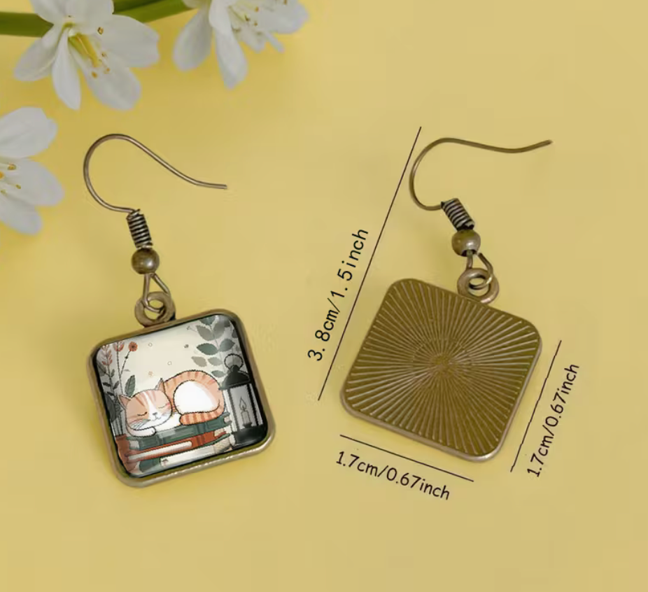 Sleeping cat on books square glass earring with antique gold-tone frame measuring approximately 1.5 inches long