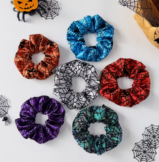 Colorful satin-style spiderweb scrunchies in orange, blue, silver, red, purple and teal, sold individually