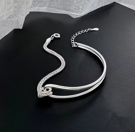 Silver-tone spliced knot double layer bracelet featuring a sleek curved bar design and adjustable chain closure.