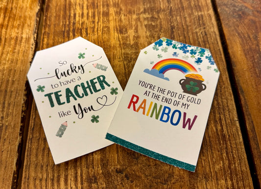 Two St Patrick’s Day gift tags with festive designs. One features the phrase You’re the Pot of Gold at the End of My Rainbow with a rainbow and gold coins, while the other reads So Lucky to Have a Teacher Like You with shamrocks.
