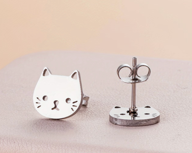 Small stainless steel cat face stud earrings with minimalist silver-tone design displayed on a neutral background
