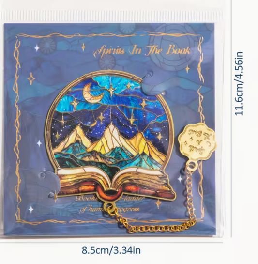 Metal book lover bookmark with mountain and starry sky design displayed on decorative blue backing card.