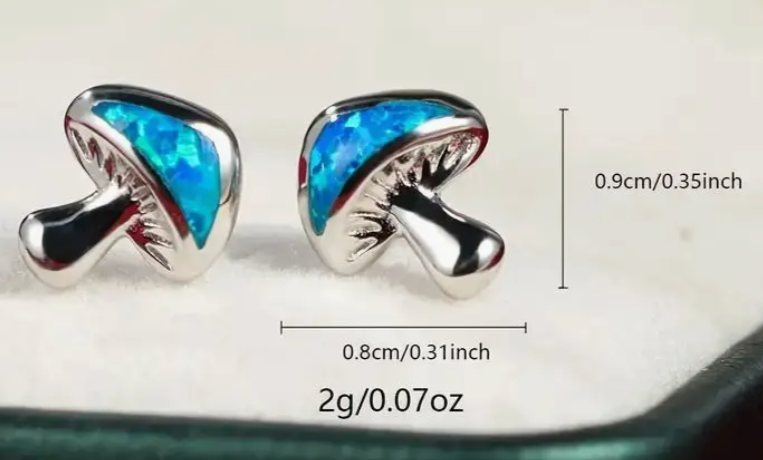 Pair of small blue mushroom stud earrings with whimsical forest-inspired design, enchanting fairycore jewelry