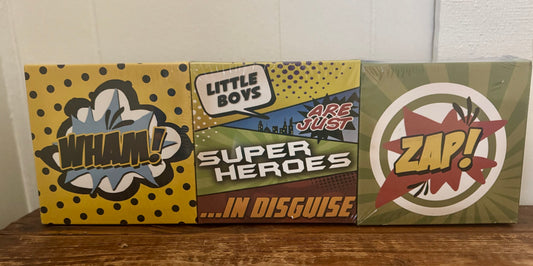 Set of 6 superhero-themed square canvases with phrases like BOOM, ZAP, WHAM, and SUIT UP in comic book style