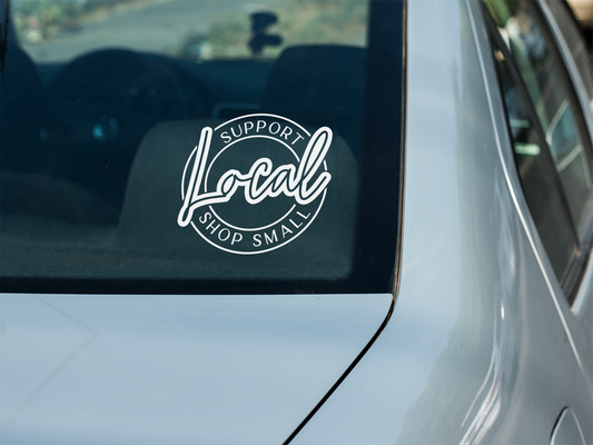 Car window with a 'Support Local, Shop Small' decal.