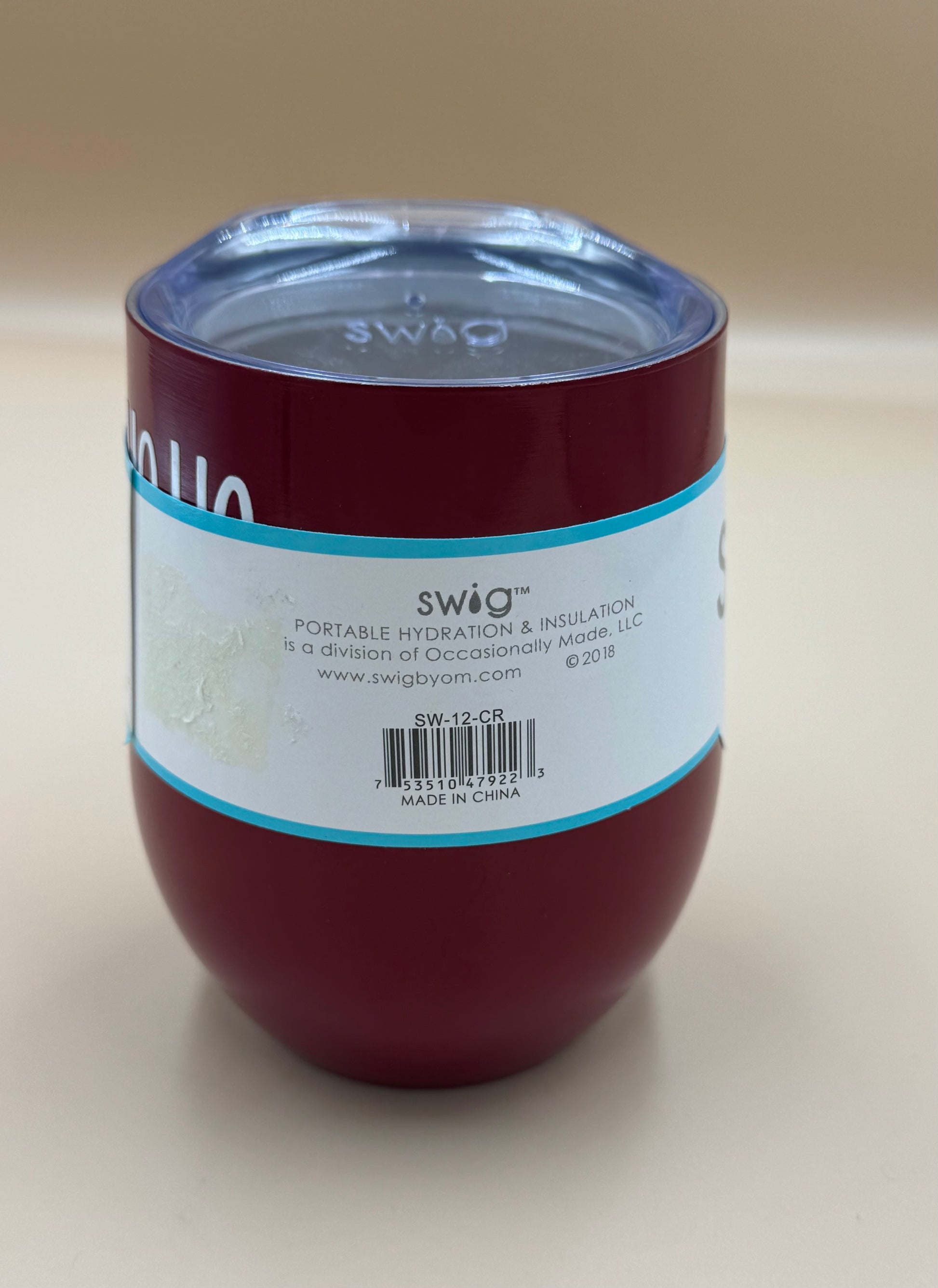 Red Swig tumbler with a label on a beige background