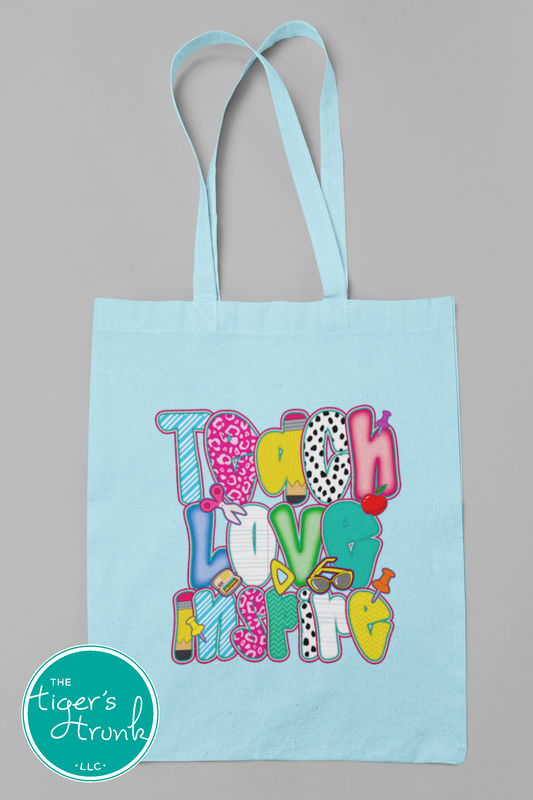 Canvas tote bag with the phrase Teach Love Inspire printed in stylish script—ideal for teachers to carry books, supplies, or everyday essentials.